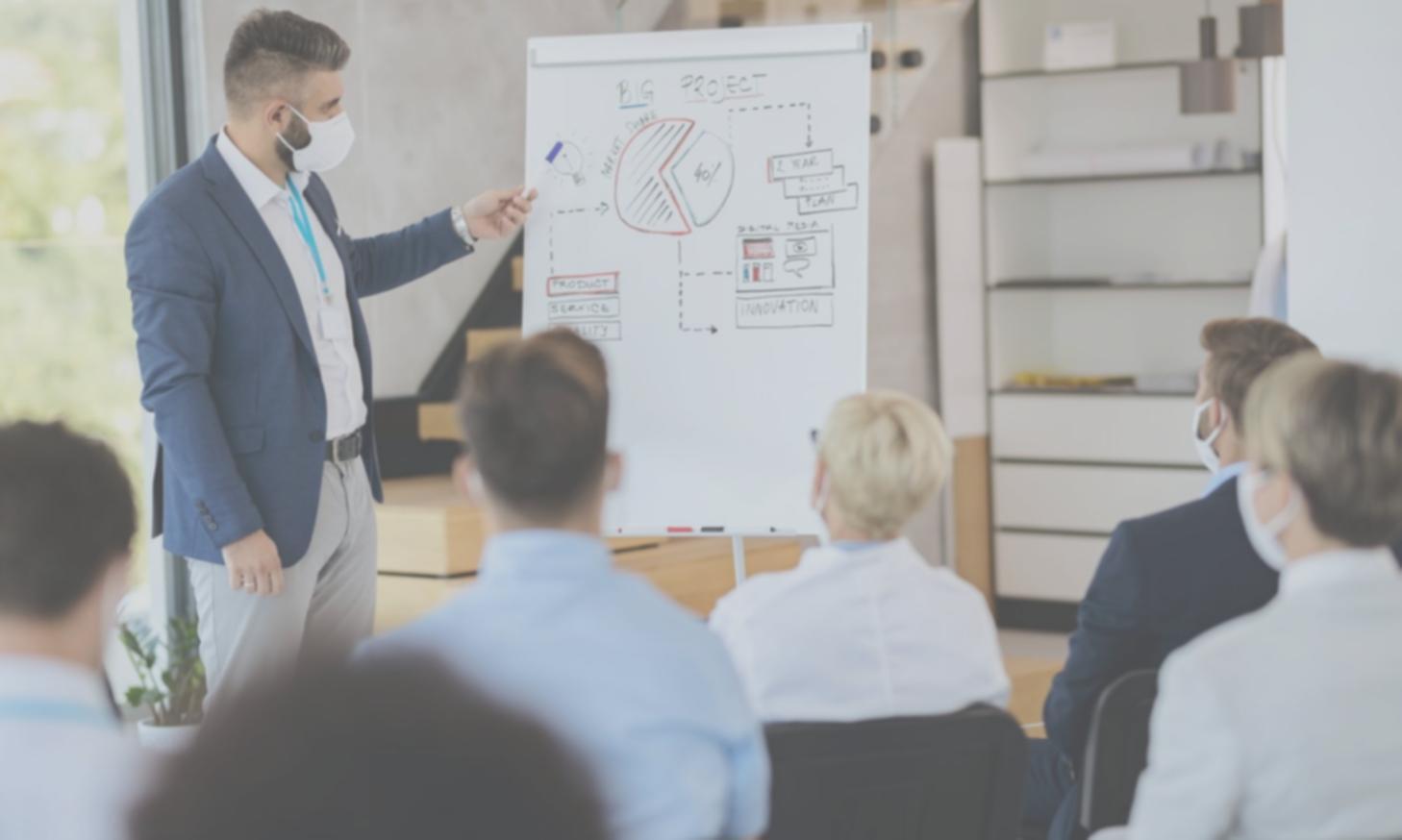 Session de planification budgétaire avec équipe travaillant sur documents et écrans